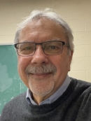 Male with short grey hair, moustache, and beard with eyeglasses.